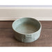 The Manor Grey Dog Bowl placed on a wooden floor.
