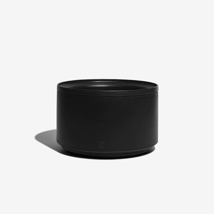 A matte black cylindrical container or planter with a matching black lid, shown on a clean white background with a soft shadow.