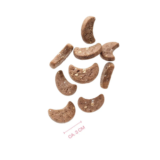 Nine brown crescent-shaped dog treats arranged on a plain white background, with a small red measurement note reading 'CA. 3 CM' near the bottom.