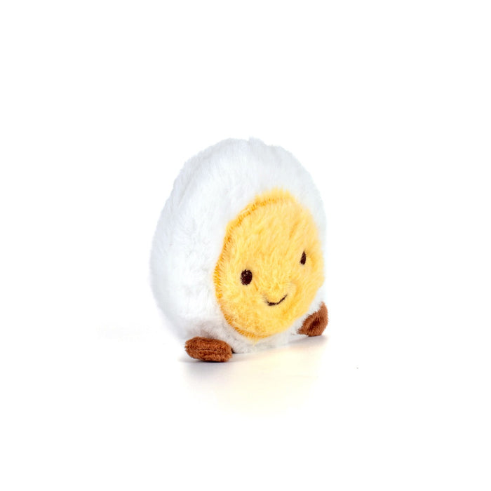 Plush toy of a cartoonish boiled egg with a smiling face on a white background