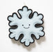 Felt snowflake ornament with a smiling face on a white background