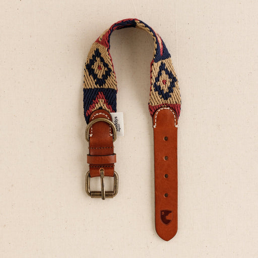 Woven belt with leather strap and buckle on a beige background