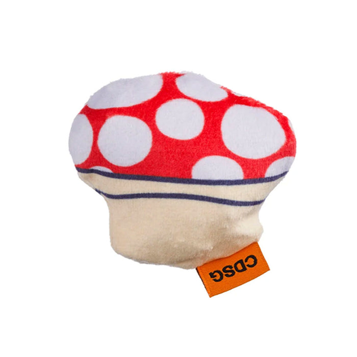 Red and white polka dot mushroom toy with a beige base and orange tag on a white background