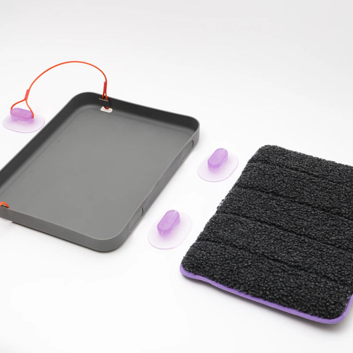 Cat bed d with purple suction cups and a black textured towel on a white background
