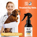 Veterinarian holding a dog with 'Our Dogs Life' kennel cleaner spray on an orange background