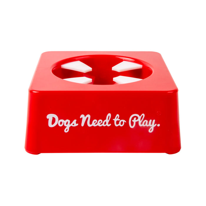 A bright red plastic dog toy or chew holder with the phrase 'Dogs Need to Play.' printed in white script on the front, shown on a plain white background.