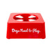A bright red plastic dog toy or chew holder with the phrase 'Dogs Need to Play.' printed in white script on the front, shown on a plain white background.