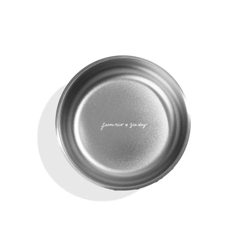 Silver lid with 'farm rio & zee dog' branding on a white background