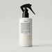 L'floof hair product bottle with a black spray nozzle on a light gray background