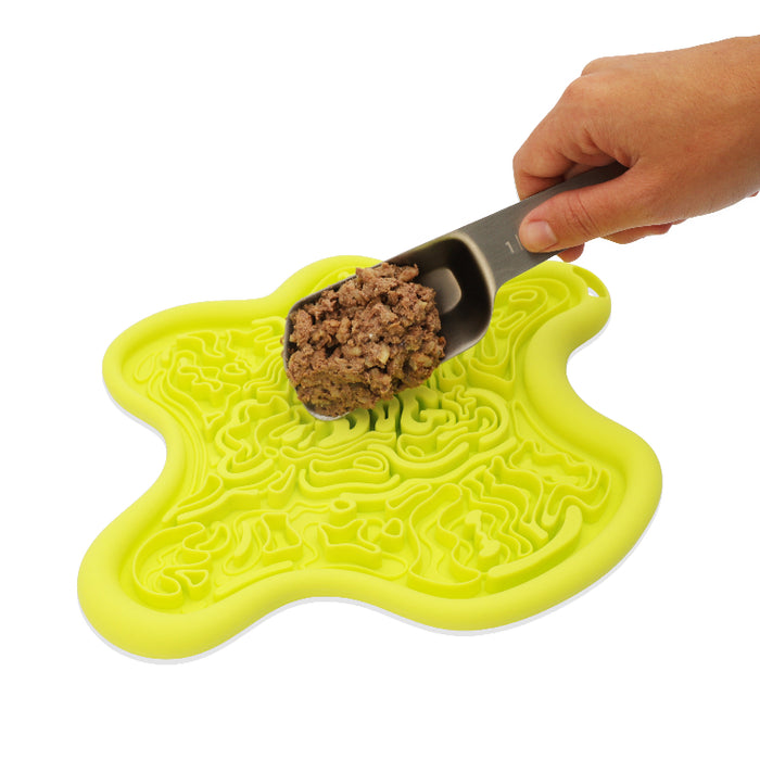 Yellow pet mat with a scoop of food on a white background