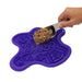 Purple pet food puzzle mat with a scoop of dog food on a white background