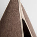 Close-up of a brown felt cone tent with a cream-colored zipper and a dark interior, set against a light gray background.