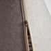 Close-up of a beige zipper running vertically down the center of a light gray fabric-covered cylindrical object, with a small metallic zipper pull visible.