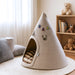 Beige pet teepee with embroidered names and a dog icon in a cozy room.