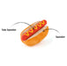 A plush hot dog toy with a red sausage, yellow mustard, and beige bun on a white background, with text labels pointing to the 'Tube Squeaker' and 'Squeaker' areas.