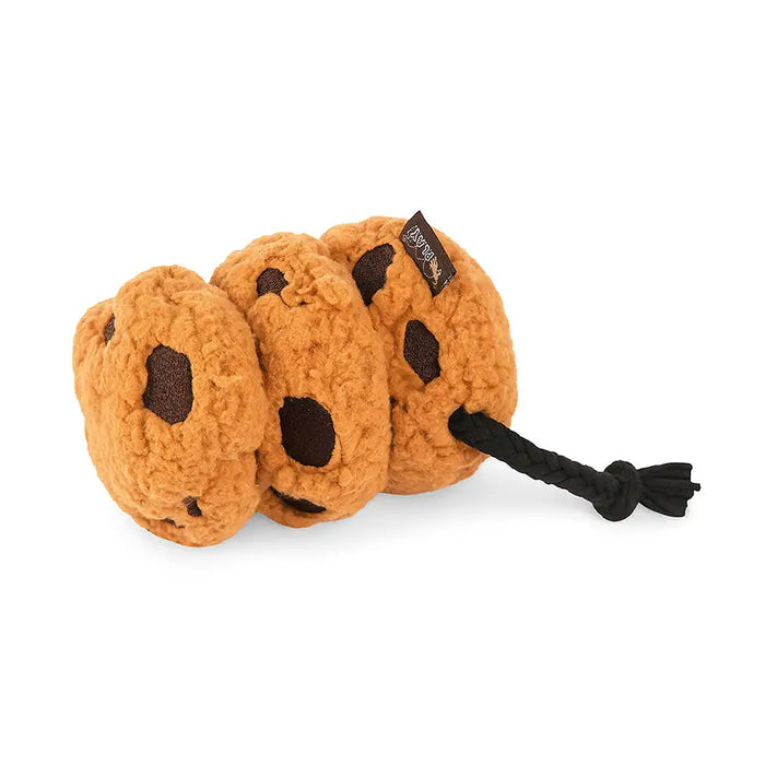 A plush dog toy shaped like three overlapping chocolate chip cookies in a warm tan-brown color, with dark brown chip details and a black rope tail, photographed on a clean white background.