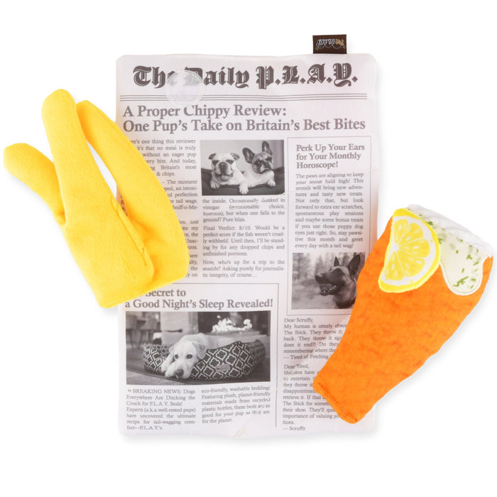 Two dog toys, one yellow and one orange with a lemon slice design, on top of a newspaper
