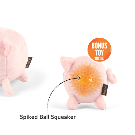 A pink plush pig toy shown from the front and back on a white background. The front view shows a sad face, and the back view shows a yellow-orange spiked ball squeaker with a black arrow pointing to it.