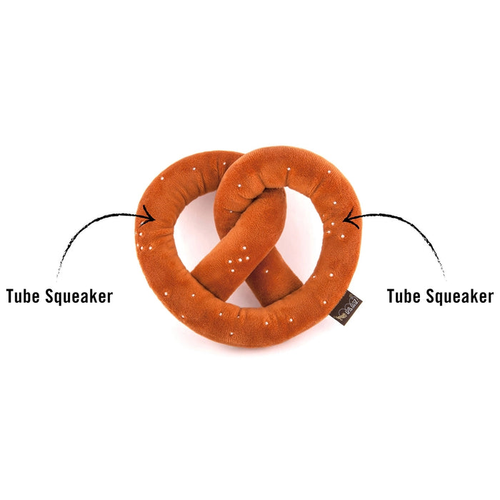 A plush pretzel-shaped tube squeaker toy in brown faux fur with white faux-seed details, shown on a white background with two callout arrows and text reading 'Tube Squeaker'.