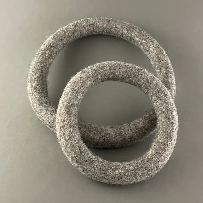 Two textured stone rings on a gray background