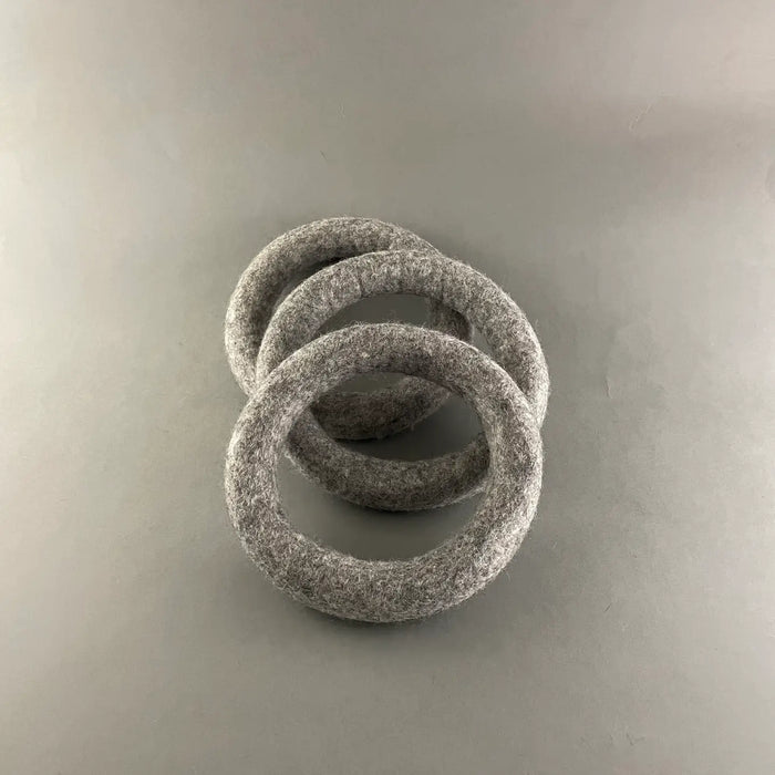 Three gray felt rings stacked on a light gray background