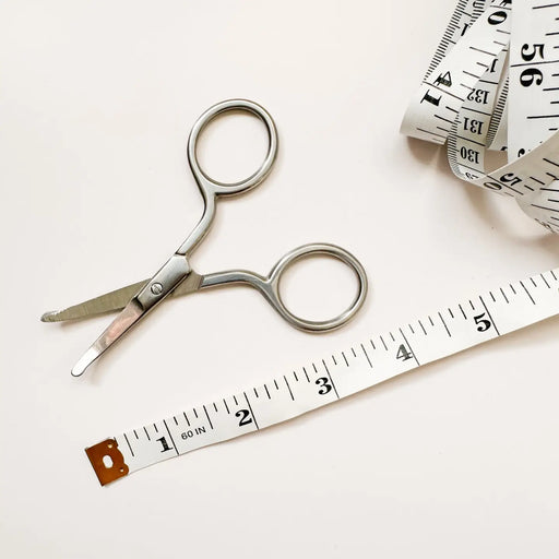Scissors and measuring tape on a white background