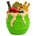 Green toy with fruit and honeycomb toppings on a white background