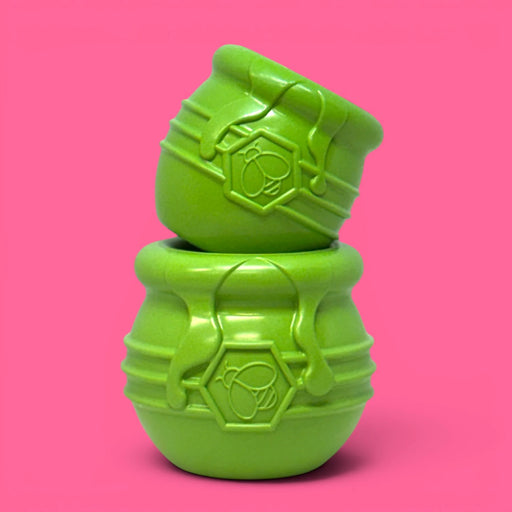 Two green textured objects stacked on a pink background