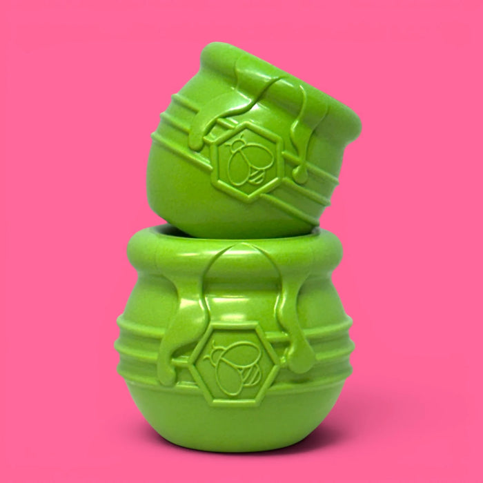 Two green textured objects stacked on a pink background