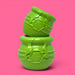 Two green textured objects stacked on a pink background
