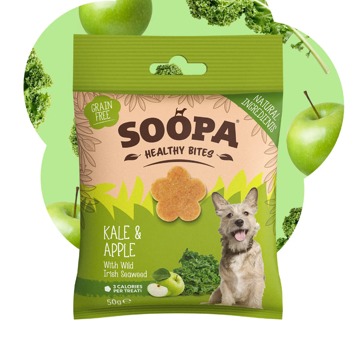 A package of Soopa Healthy Bites dog treats, Kale & Apple flavor, featuring a green and beige bag with a picture of a dog and illustrations of kale and apple, set against a light green background with whole kale and apple graphics.