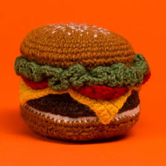 Knitted hamburger toy on an orange background