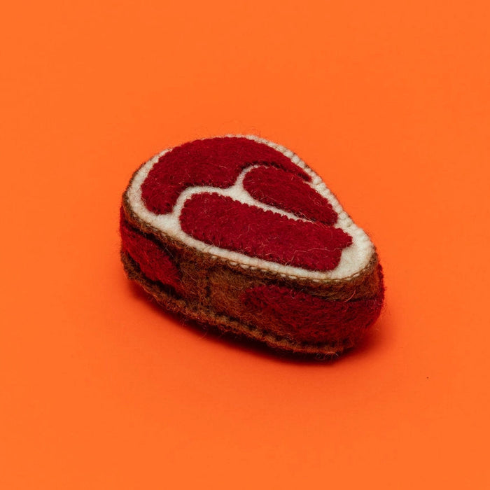 Felted toy resembling a steak on an orange background