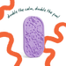 A purple silicone bath sponge with embossed bath-themed icons, shown on a white background with orange scribbled accents and the text 'double the calm, double the fun!'.