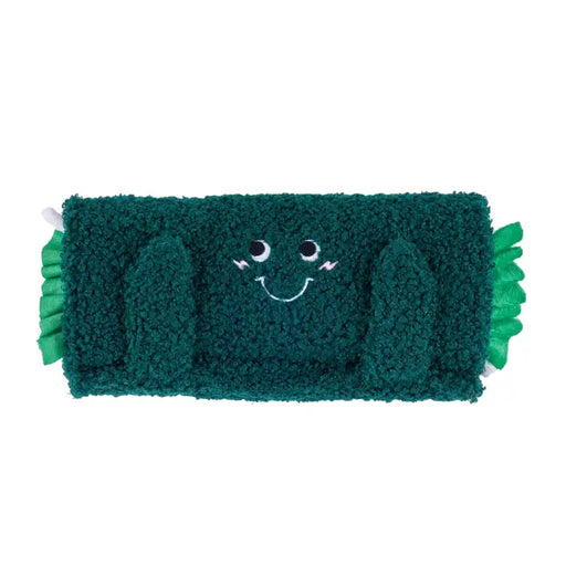 Green plush toy with a smiling face on a white background