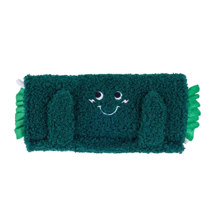 Green plush toy with a smiling face on a white background
