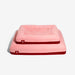Pink pet bed with a red base on a white background