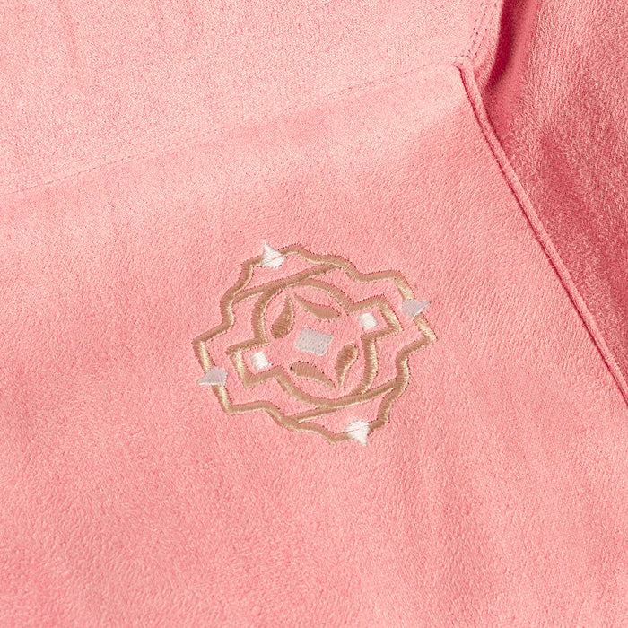 Close-up of a pink fabric with an embroidered design.