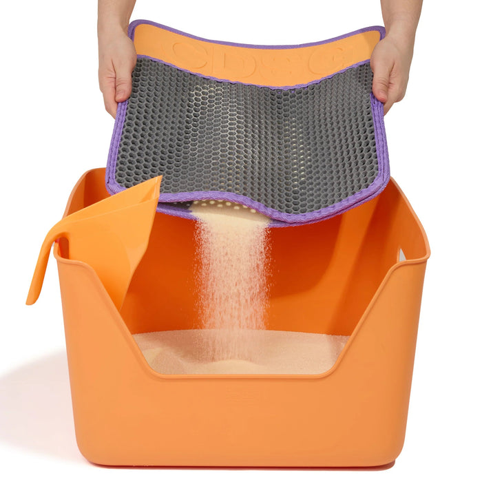 Orange pet litter box with a gray mesh cover and purple rim, held by a person.