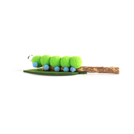 A green caterpillar-themed hair claw clip featuring bright green fuzzy segments, small blue bead details, a green leaf base, and a brown twig tail on a plain white background.