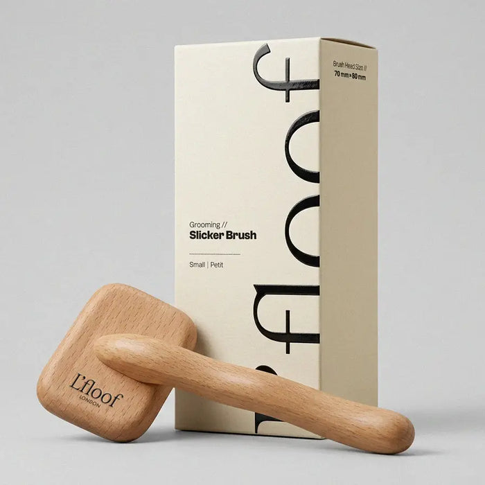 Wooden grooming slicker brush with L'loof packaging on a gray background