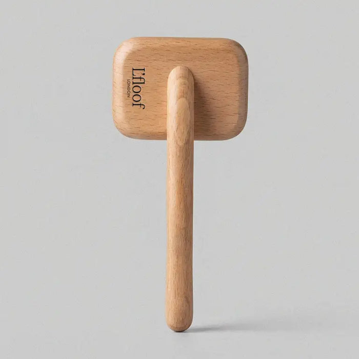 Wooden hook with a square wooden block on a gray background