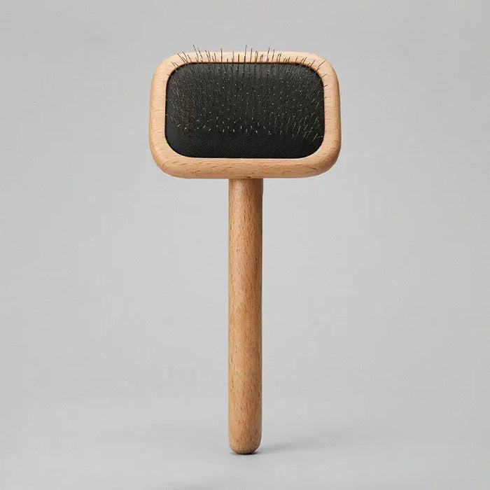 Wooden brush with black bristle head on a gray background
