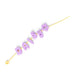 Purple letter beads spelling 'daisy' on a yellow string against a white background