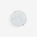Round, white airtag holder with colourful specks on a light grey background