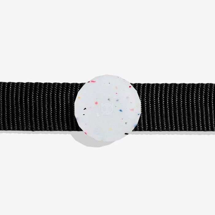 Black dog collar with a Round, white airtag holder with colourful specks on a light grey background
