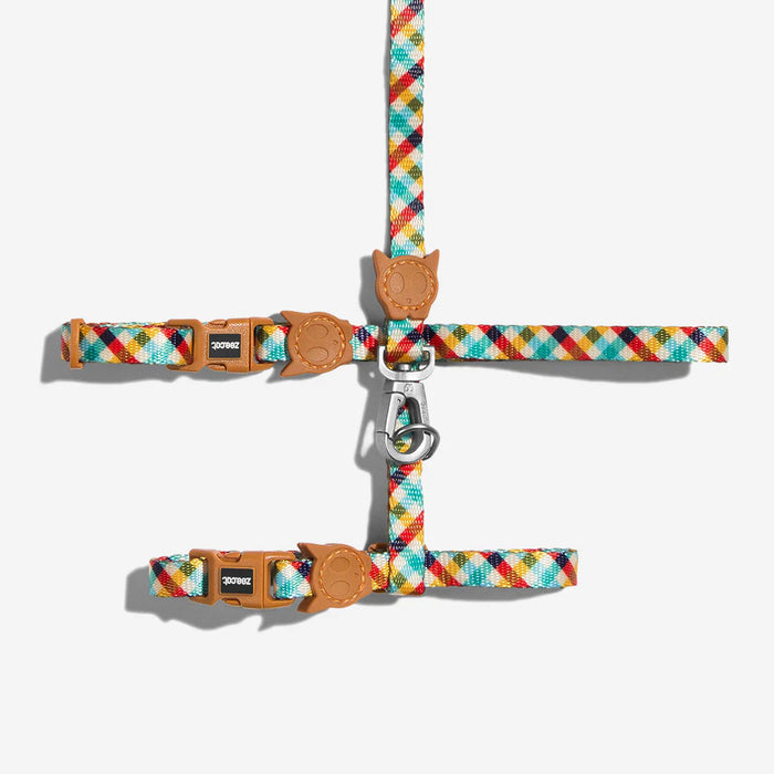 Colorful plaid cat halter with brown leather straps on a white background