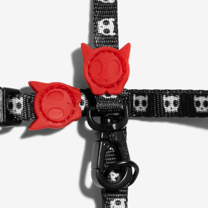 Black pet collar with red cat-shaped buckle on a white background