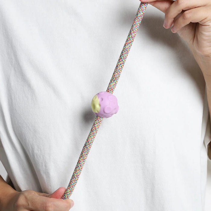 purple and green moon rubber pinz with hands on a rope lead and white t shirt