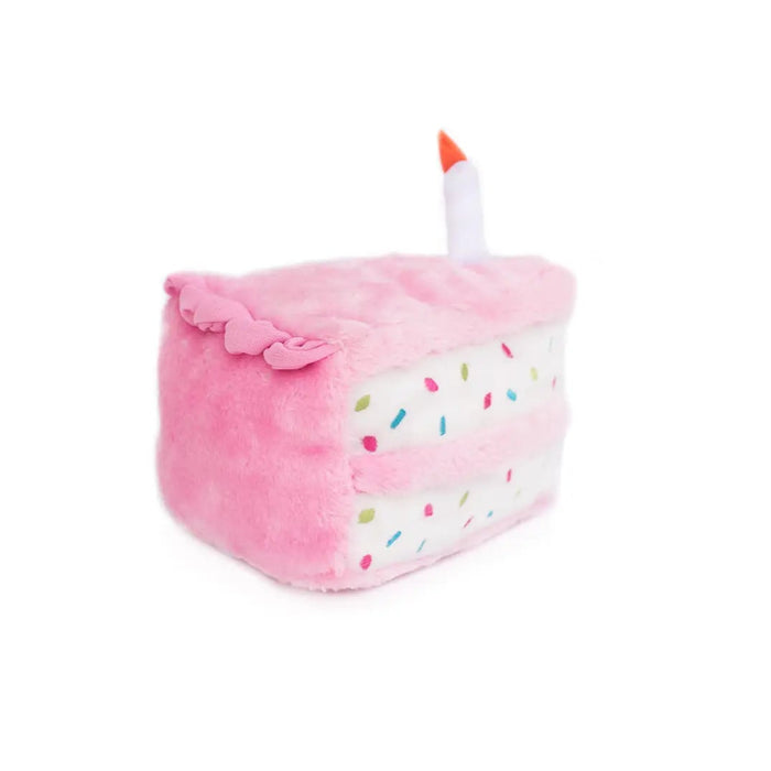 Pink plush toy shaped like a cake with a candle on a white background
